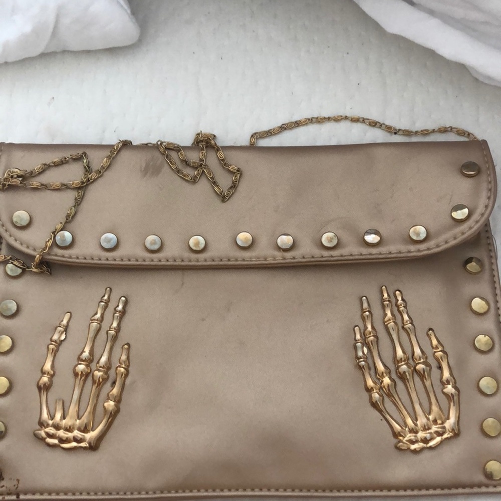 large flat skull hands clutch skeleton
